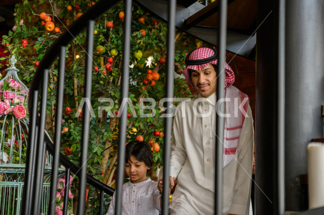 A Saudi Arabian Gulf family climbing the restaurant stairs, spending quality time inside the restaurant, enjoying and entertaining on vacation, family atmosphere, Saudi restaurants and cafes