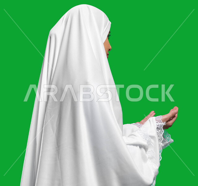 المحافظة على الصلوات الخمس, فضل العمرة في شهر رمضان المبارك، لباس الحشمة و الستر للمرأة المسمله, التقرب إلى الله بالدعاء و التضرع، بورتريه من الجانب لامرأة عربية سعودية خليجية ترتدي ملابس الصلاة البيضاء, اداء مناسك الحج والعمرة، كروما، خلفية خضراء.
