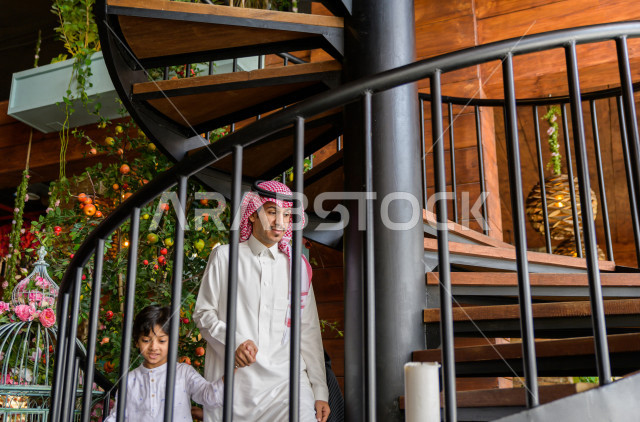 عائلة عربية سعودية خليجية تصعد درج المطعم ، قضاء وقت ممتع داخل المطعم ، الاستمتاع و الترفيه في العطلة ، اجواء عائلية ،مطاعم وكافيهات السعودية