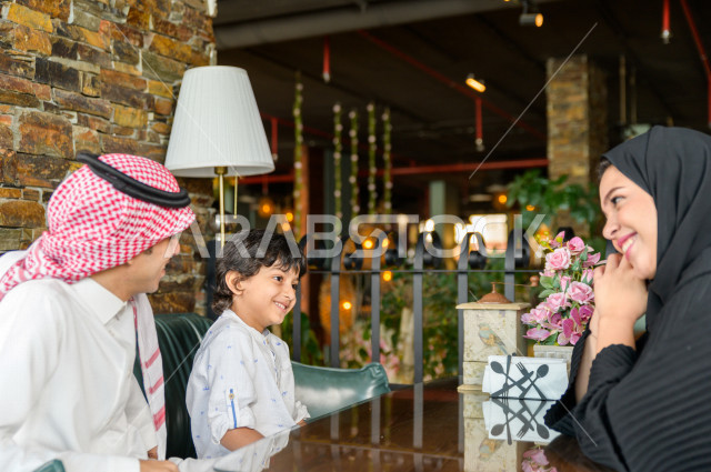 عائلة عربية خليجية سعودية تقضى وقتا ممتعا على مائدة الطعام في المطعم ، قضاء أوقات عائلية ترفيهية ، قضاء العطلة مع العائلة ، جلسات فريدة و مميزة ، مطاعم و كافيهات في السعودية