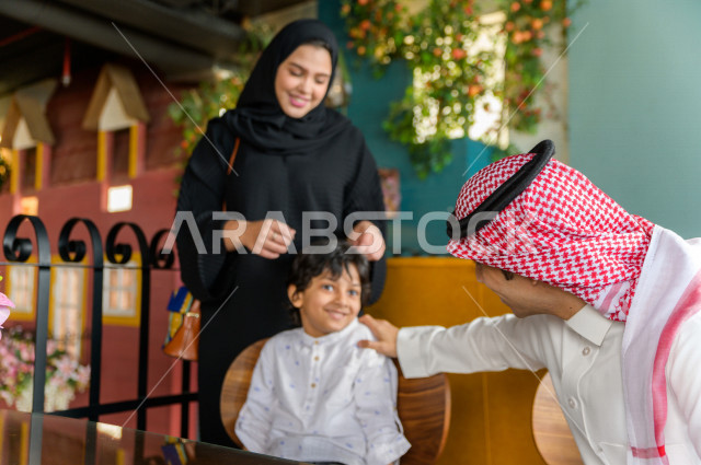 عائلة عربية خليجية سعودية تقضى وقتا ممتعا على مائدة الطعام في المطعم ، قضاء أوقات عائلية ترفيهية ، قضاء العطلة مع العائلة ، جلسات فريدة و مميزة ، مطاعم و كافيهات في السعودية