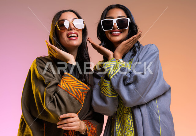 Modern Gulf women's abayas, a portrait of two Saudi Arab Gulf women, the concept of fashion and elegance, wearing sunglasses, a colorful background, chatting and dialogues between girlfriends, gestures of kindness and femininity