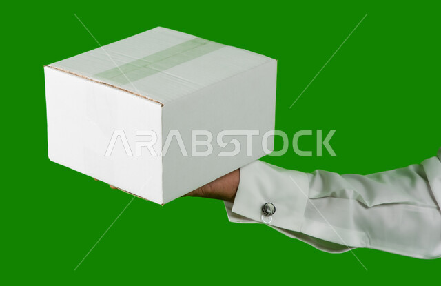 Delivery of orders and goods to customers, portrait of a Saudi Arabian Gulf man holding a white box, mockup of a laminated carton box, online shipping and delivery cartons, packaging cardboard boxes, express and security delivery services, chroma green ba