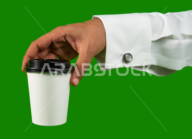 Chroma green background, buying fresh coffee from Saudi cafes, LED portrait of a Saudi Arabian Gulf man holding a cup of coffee, fast and safe delivery services for hot drinks, mock-up of a cardboard cup, delivery of purchases and orders to customers
