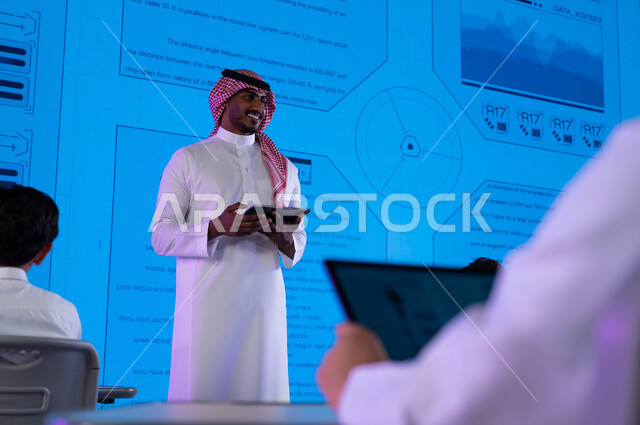 أساليب وإستراتيجيات جديدة في نظام  التعليم في المدارس السعودية، مجموعة من الطلاب العرب الخليجيين السعوديين يتابعون شرح الدروس مع المعلم من خلال جهاز التابليت، التعليم المتطور باستخدام شاشات إلكترونية وتقنيات حديثة، رؤية مستقبلية 2030