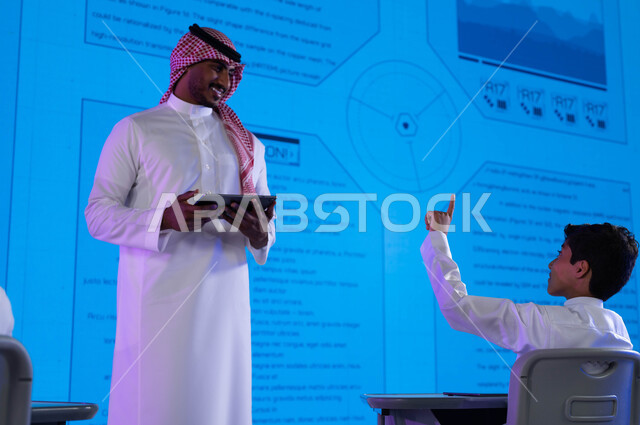 Future vision 2030, integrating education with technology, a Saudi Arabian Gulf teacher using a tablet in explanation and clarification, new methods and strategies in the education system in Saudi schools, advanced education using electronic screens and m