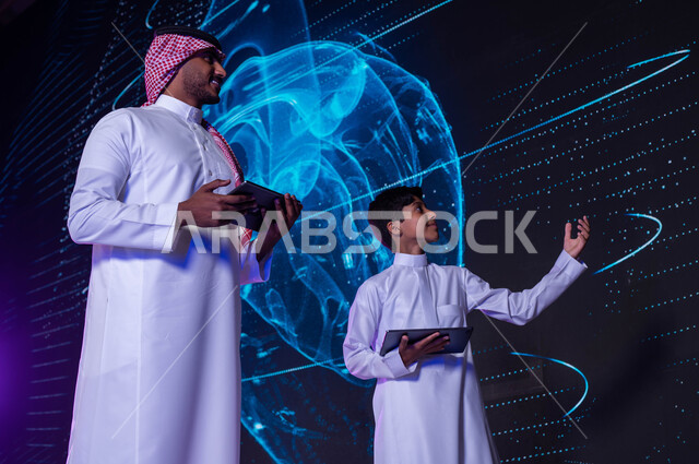 بناء مهارات التفكير الابداعي، شرح وتوضيح مخطط أعضاء جسم الإنسان بالتكنولوجيا العلمية المتطورة، طالب ومدرس عربيان خليجيان سعوديان يستخدمان جهاز التابليت، خلفية شاشات هولوجرامية ثلاثية الأبعاد لقلب الإنسان، رؤية مستقبلية 2030