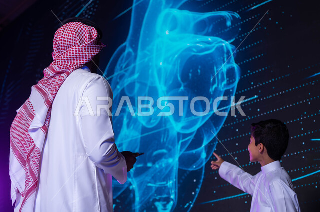 خلفية شاشات هولوجرامية ثلاثية الأبعاد لقلب الإنسان، شرح وتوضيح مخطط أعضاء جسم الإنسان بالتكنولوجيا العلمية المتطورة، طالب ومدرس عربيان خليجيان سعوديان يتناقشان ويتحاوران، بناء جيل جديد متطور ومبدع، رؤية مستقبلية 2030