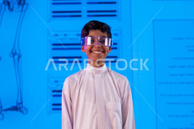 التعليم المتطور بإستخدام شاشات إلكترونية وتقنيات حديثة، أساليب وإستراتيجيات جديدة في نظام  التعليم في المدارس السعودية، طالب عربي سعودي خليجي مبتسم يرتدي نظارات الواقع الإفتراضي وينظر للكاميرا، إيماءات وجه تدل على السعادة، رؤية مستقبلية 2030