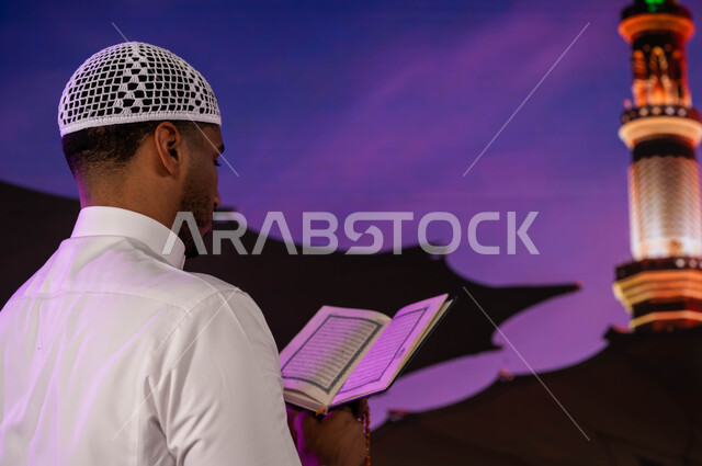 خلفية المئذنة و المظلات الإلكترونيه، فضل الصلاة و الدعاء في المسجد النبوي الشريف، قدوم المسلمين من شتى أنحاء العالم الى الأماكن المقدسه في المدينة المنورة، صورة من الخلف لرجل عربي سعودي يقوم بقراءة و تلاوة القرآن، العبادة و التقرب إلى الله في المسجد رسول