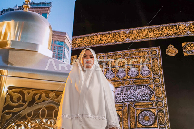Close to God by performing obedience, the need for an Indonesian Muslim woman wearing white prayer clothes looking at the camera, performing the rituals of Hajj and Umrah, the virtue of Umrah in the month of Ramadan, the arrival of pilgrims from outside S