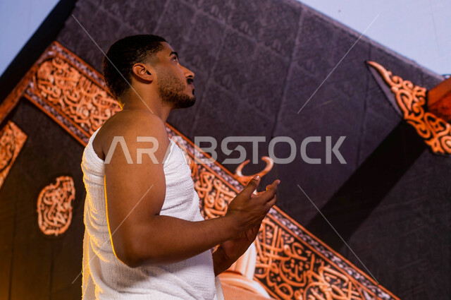 أداء مناسك الحج والعمرة, فضل العمرة في شهر رمضان المبارك, أداء فريضة الحج في ذي الحجة, صورة من الجانب لحاج عربي سعودي خليجي يرتدي زي الإحرام, الطواف حول الكعبة, الدعاء والتوسل إلى الله في المسجد الحرام, صورة مقربة لميزاب الكعبة المشرفة