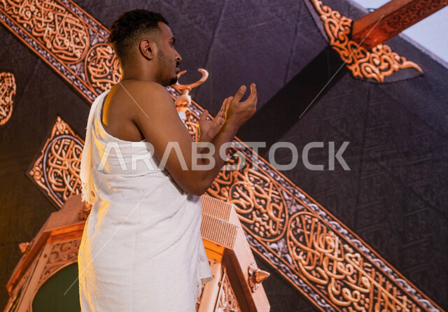 أداء فريضة الحج في ذي الحجة, فضل العمرة في شهر رمضان المبارك, صورة من الجانب لحاج عربي سعودي خليجي يرتدي زي الإحرام ويطوف حول الكعبة المشرفة في مكة المكرمة, الدعاء والتوسل إلى الله في المسجد الحرام, صورة مقربة لميزاب الكعبة المشرفة