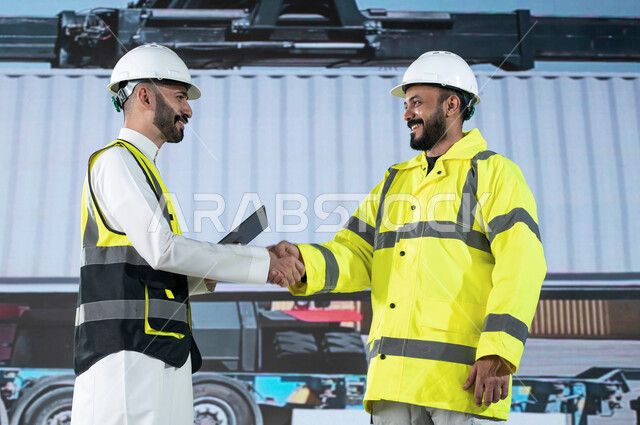 التصافح لنجاح وانجاز خطة العمل المتفقة, ميناء شحن البضائع و الحاويات التجاريه، مهندسان عربيان سعوديان خليجيان يقومان بالاشراف على توصيل ونقل الكونتينرات بإستخدام جهاز التابلت، استخدام الآلات المتطوره الحديثه في الإستيراد والتصدير, رؤية مستقبلية 2030.
