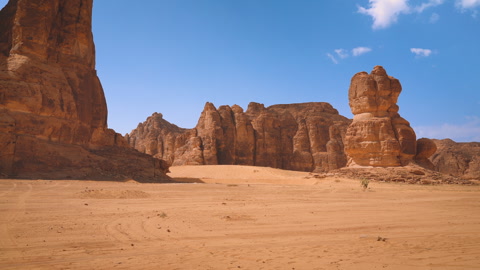 Rocky desert formations with sand in foreground, typical landscape of Al Ul..