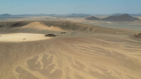 Camera drone flies backwards over a crater in the Harrat Kishb volcanic field