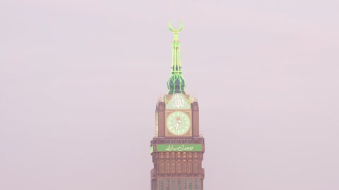 تصوير زمني لغروب الشمس على مبنى برج الساعة الملكي في مكة المكرمة