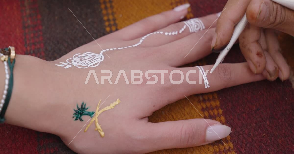 The use of white henna in engraving and painting on the hand, the emblem of the Kingdom of Saudi