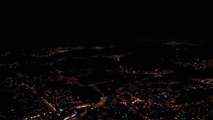 Car traffic in the illuminated roads and streets at night time, drone photography of the city of Makkah Al-Mukarramah at night in the Kingdom of Saudi Arabia, the landmarks of the city of Makkah Al-Mukarramah, buildings and residential houses.