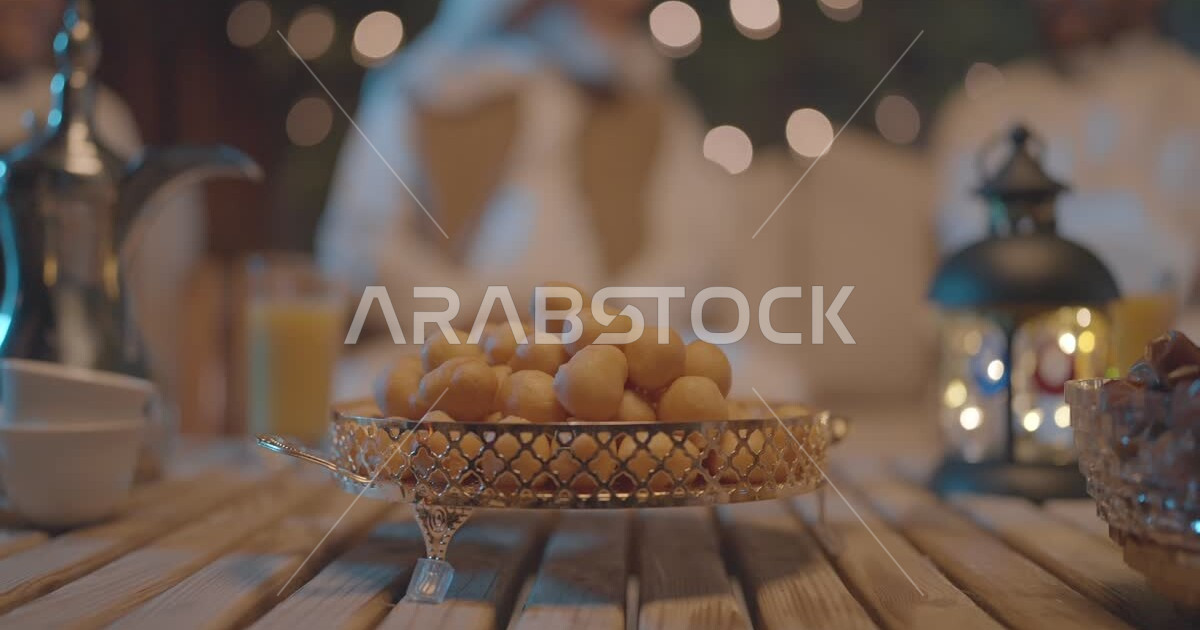 Popular Arabic sweets, a Saudi Arabian Gulf girl offering a solution of Luqma alQadi to her