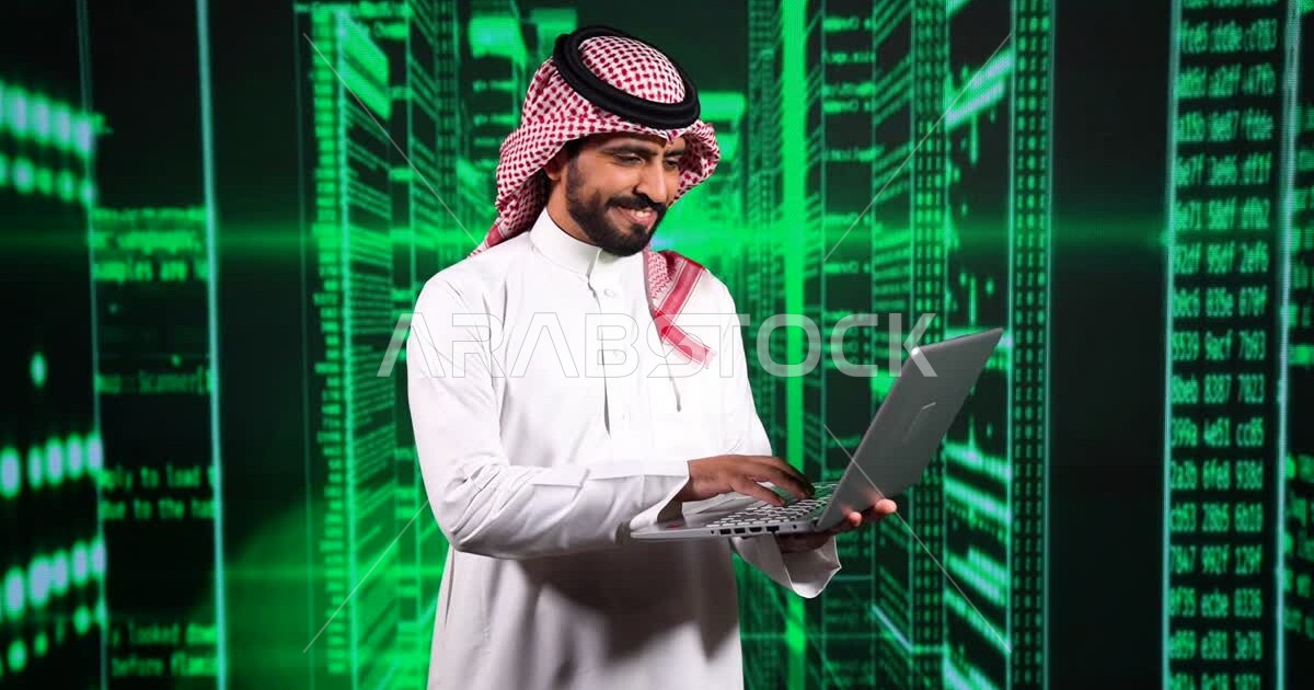 A young Saudi Gulf Arab working as a web developer, using a variety of ...