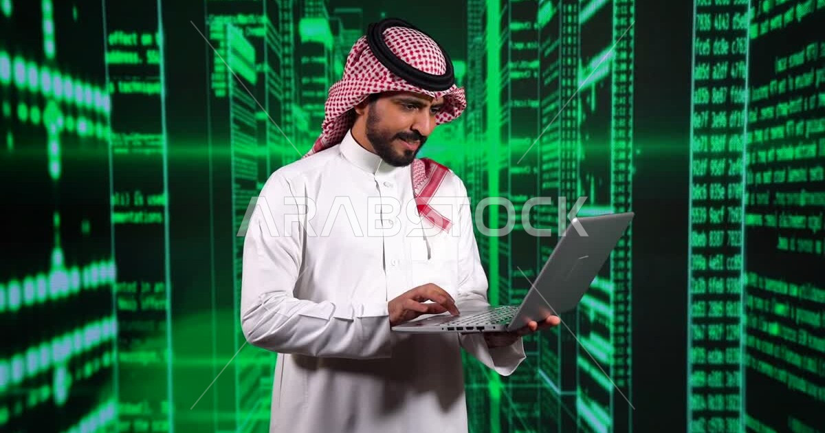 A young Saudi Gulf Arab working as a web developer, using a variety of ...
