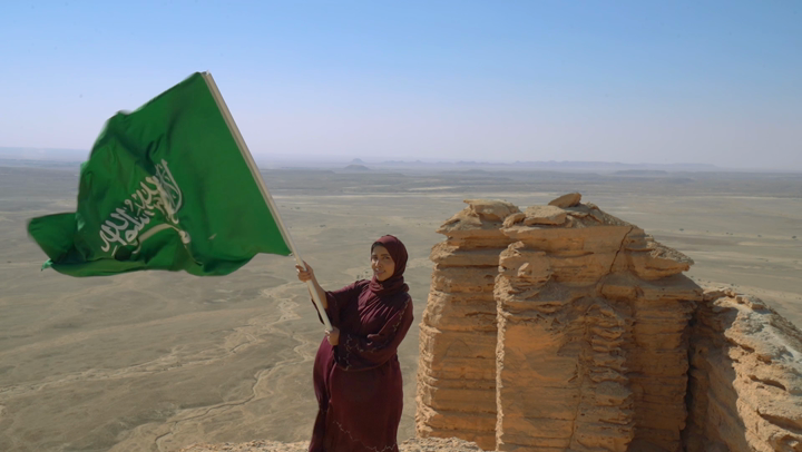 A Saudi Arabian woman carrying her hand with Saudi Arabia, standing in the area of the end of the world tourism in Riyadh, Saudi National Day, National Day, Sahrawi areas, beauty of Saudi Arabia