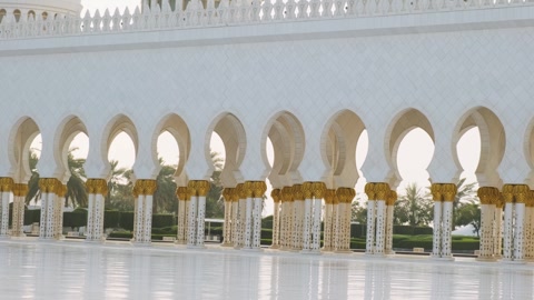 Cortyard view of Sheikh Zayed Grand Mosque with ornate columns with golden paln