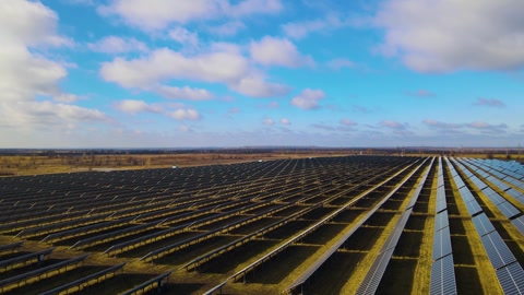 Aerial view of a large power plant with many rows of solar photovoltaic panel