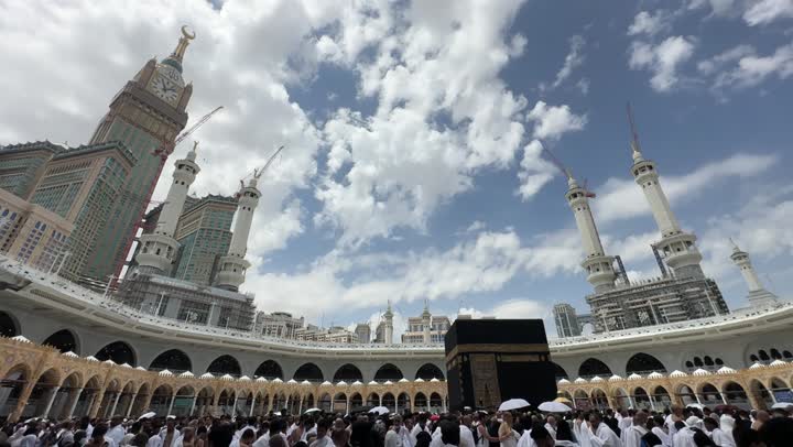 Islamic religious landmarks, the Grand Mosque in Mecca, Saudi Arabia, performing Hajj and Umrah rituals, worship and drawing closer to God, Muslim pilgrims and Umrah performers circumambulating the Kaaba, the distinctive architecture of the Royal Clock Tower building, Islamic holy places