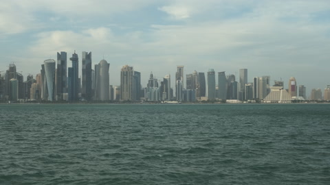 Doha skyline from the corniche promenade afternoon zooming in shot