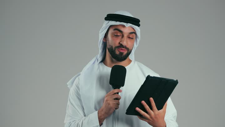 قراءة الملاحظات والمعلومات، بورتريه لرجل عربي خليجي اماراتى يرتدي الكندوره والغتره يحمل بيده الجهاز اللوحى ومكبر الصوت يقوم بإلقاء الخطابات، القيام بالحوارات والنقاشات، إعداد وتحضير أفكار الخطاب بشكل مسبق، خلفية رمادية