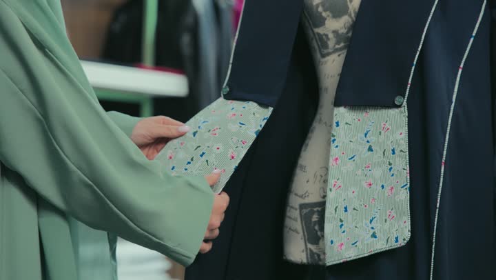 A photograph of a smiling Emirati Gulf Arab woman wearing an elegant colorful abaya, women's abayas with distinctive modern designs, women's clothing with modern designs, a Saudi woman buying new clothes, veiled fashion, following fashion and trends