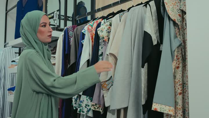 The concept of fashion and elegance, veiled fashion, women's abayas with distinctive modern designs, Gulf abayas models, photography of a smiling Emirati Gulf Arab woman wearing an elegant colorful abaya, a Saudi woman buying new clothes, following fashion and trends