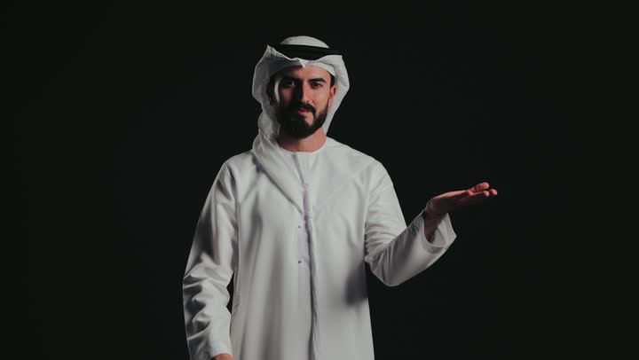 إيماءات حمل ورفع شيء ما، تصوير لرجل عربي خليجي إماراتي يرتدي الكندورة الإماراتية والغتره البيضاء يشير باصبع السبابة ليده، الإشارة نحو هدف ما، حركة أصابع وإشارات .