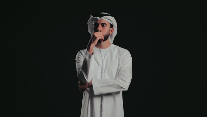 التفكير ومحاولة إيجاد حل للمشكلات, النظر بتمعن والتخطيط للمستقبل, شرود الذهن واتخاذ القرارات بتركيز, تصوير لشاب عربي خليجي إماراتي يرتدي الغتره والكندورة ينظر إلى شيء ما