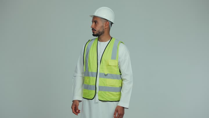 الإشراف والتوجيه وإعطاء الأوامر، الإعمار بسواعد أبناء الوطن، رجل عربي خليجي اماراتي يرتدي الكندورة والخوذة وبدلة السلامة يشير بإصبع السبابة إلى شيء ما، لباس رسمي للعمل في القطاع الهندسي والمشاريع ، خلفية بيضاء