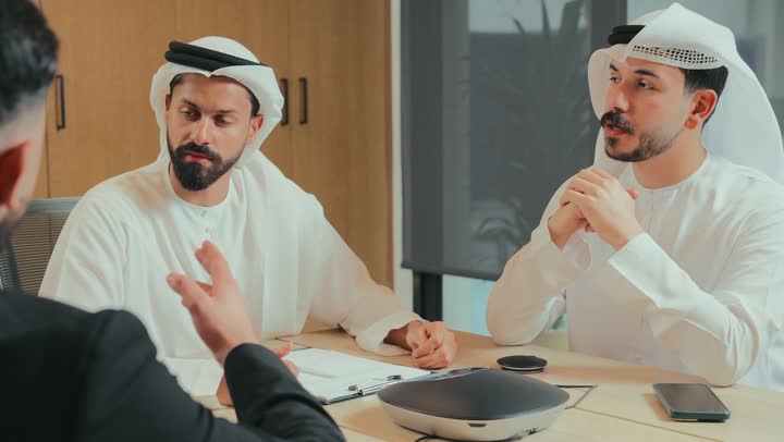 استخدام جهاز مكبر صوت للاجتماعات، ورش عمل وتدريب، فريق عربي خليجي اماراتي مجتمعون داخل مقر الشركة لدراسة وتحليل المشاريع، اجراء اجتماع لتبادل الخبرات والمعلومات، تطوير الأعمال وحل المشكلات، الوحدة والعمل الجماعي، مهنة ووظيفة إماراتية مكتبية، استعمال جهاز تقني حديث