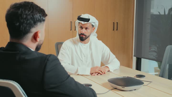استخدام جهاز مكبر صوت للاجتماعات، ورش عمل وتدريب، فريق عربي خليجي اماراتي مجتمعون داخل مقر الشركة لدراسة وتحليل المشاريع، اجراء اجتماع لتبادل الخبرات والمعلومات، تطوير الأعمال وحل المشكلات، الوحدة والعمل الجماعي، مهنة ووظيفة إماراتية مكتبية، استعمال جهاز تقني حديث