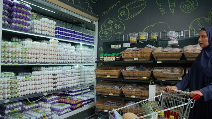 السهولة والراحة في التسوق, قضاء وقت ممتع في التبضع واختيار اللوازم المنزليه, امتلاك خيارات شراء و استهلاك مختلفة من السوبر ماركت، سيدة عربيه خليجية اماراتيه محجبة ترتدي عباءه رماديه تمشي في أحد أقسام الماركت وتقوم بجرعربة التسوق، منتجات محليه وطنيه