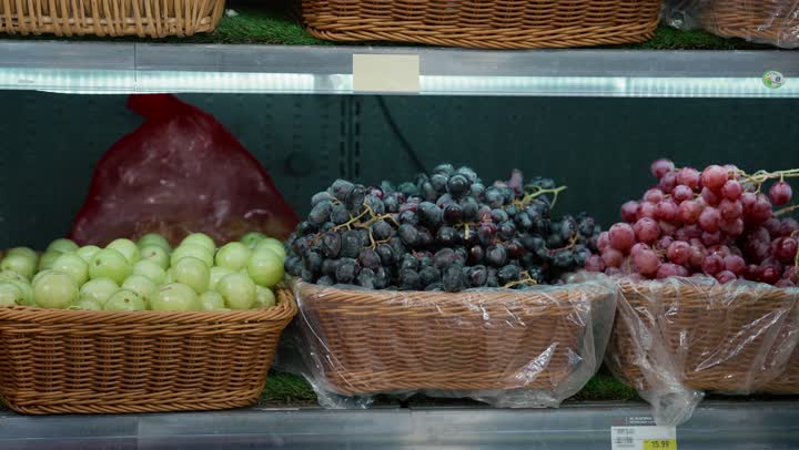 Straw plates filled with various fruits, the perfect choice for apples, an Arab Gulf Emirati girl buying red apples with her mother in the supermarket, a Saudi woman wearing a gray abaya shopping, goods and food supplies, a local national product