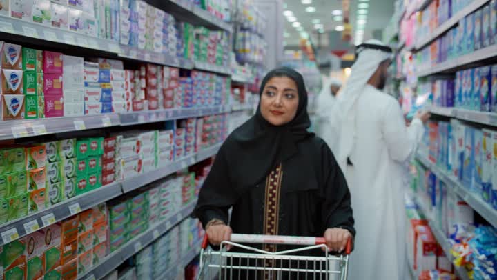 التجول في قسم المنظفات والمطهرات، امتلاك خيارات شراء و استهلاك مختلفة في السوبرماركت، سيدة عربيه خليجية إماراتية محجبة ترتدي العباءة تمشي في أحد أقسام الماركت وتقوم باختيار نوع الصابون المناسب، قضاء وقت ممتع في اختيار اللوازم المنزليه, السهولة والراحة في التسوق