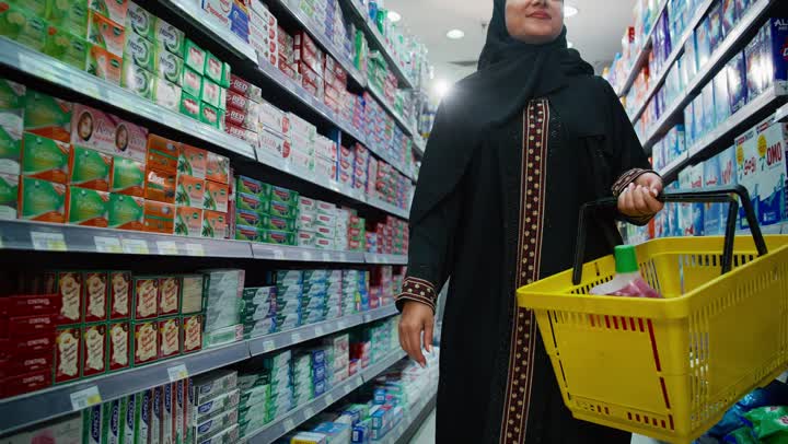 التجول في قسم المنظفات والمطهرات، امتلاك خيارات شراء و استهلاك مختلفة في السوبرماركت، سيدة عربيه خليجية إماراتية محجبة ترتدي العباءة تمشي في أحد أقسام الماركت وتقوم باختيار نوع الصابون المناسب، قضاء وقت ممتع في اختيار اللوازم المنزليه, السهولة والراحة في التسوق