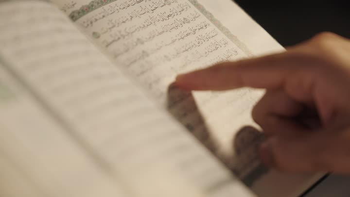 أداء مناسك الحج والعمرة، التقرب الى الله بالعبادة والطاعة, تلاوة كتاب الله، قراءة القرآن الكريم بتمعن وتركيز, تصوير لرجل عربي سعودي خليجي يرتدي ملابس الإحرام ويمسك بين يديه المصحف الشريف