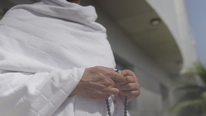 قدوم الحجاج من داخل السعودية, مفهوم أركان الإسلام وأداء الفرائض الدينية، قدوم الحجاج من داخل السعودية, أداء العمرة في مكة المكرمة في شهر رمضان المبارك، حاج عربي سعودي يرتدي ملابس الإحرام يمسك بيده السبحه ، أداء مناسك الحج والعمره
