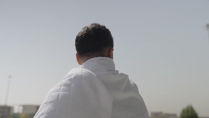 مفهوم أركان الإسلام وأداء الفرائض الدينية، قدوم الحجاج من داخل السعودية, أداء العمرة في مكة المكرمة في شهر رمضان المبارك، حاج عربي سعودي يرتدي ملابس الإحرام ، أداء مناسك الحج والعمره