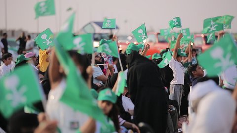 رفع اعلام المملكة العربية السعودية، راية التوحيد والإسلام وشعار الهوية الوطنية، احتفال المواطنون السعوديون في الطريق، مفهوم حب الوطن والانتماء اليه، الاخلاص والولاء للبلاد، الاحتفال بالمناسبات والاعياد الوطنية، ذكرى العيد الوطني 23 سبتمبر، يوم العلم 11 مارس