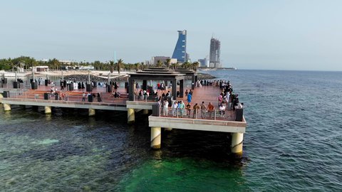 الاهتمام بزراعة أشجار النخيل، مرور الدراجات الهوائية على ممر السعادة في كورنيش مدينة جدة في المملكة العربية السعودية في النهار، الأبراج وناطحات السحاب المطلة على ساحل البحر الأحمر، مكان ومنطقة سياحية مشهورة