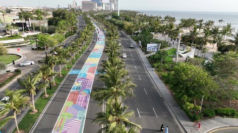 الاهتمام بزراعة أشجار النخيل، مرور الدراجات الهوائية على ممر السعادة في كورنيش مدينة جدة في المملكة العربية السعودية في النهار، الأبراج وناطحات السحاب المطلة على ساحل البحر الأحمر، مكان ومنطقة سياحية مشهورة