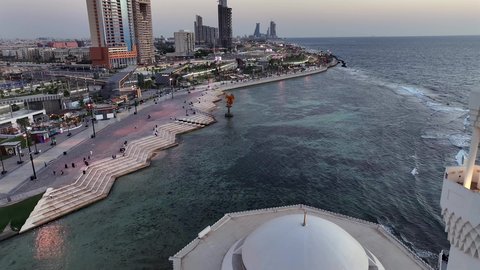 مسجد الرحمة العائم على البحر الأحمر في مدينة جدة في المملكة العربية السعودية، الفن الهندسي المعماري للابراج المطلة على ساحل الخليج العربي، الواجهه البحرية في النهار، تصوير درون جوي لكورنيش جدة السياحية